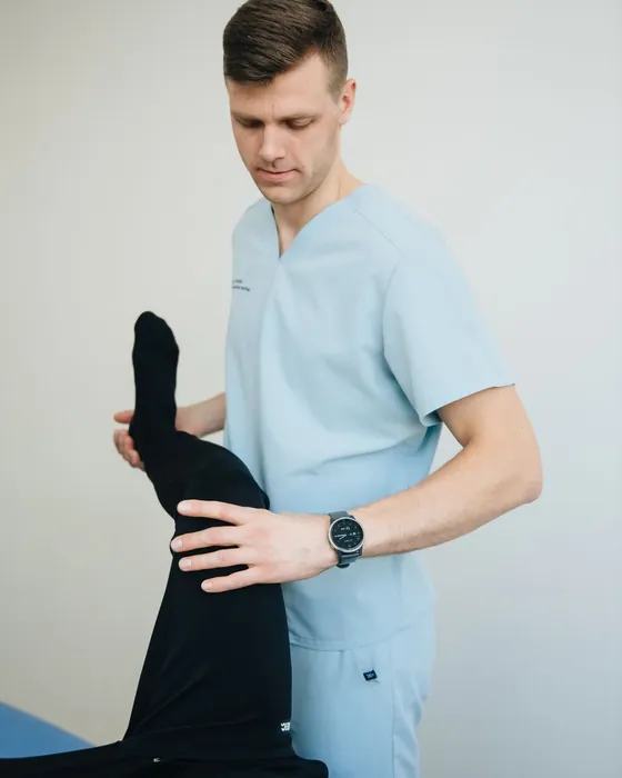 A physiotherapist stretching a patient's leg